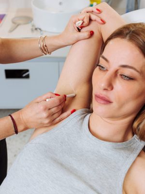 Preparation for Hyperhidrosis Anti-Sweating Injection A girl preparing to receive a hyperhidrosis anti-sweating injection to reduce excessive sweating.